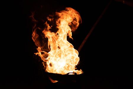 Red orange flame from the fire on the pan roasting cashews.
fire,heat energy that ignites fuel at night
black background. select focus.の写真素材