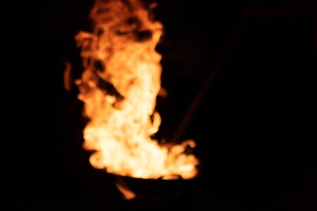 Defocused and blurred image for background. Red orange flame from the fire on the pan roasting...
