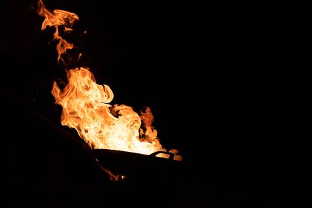 Red orange flame from the fire on the pan roasting cashews.fire,heat energy that ignites fuel at...