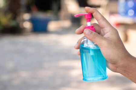 Hand sanitizer, alcohol bottle, held in hand. Disinfecting concept: liquid soap, squeezing blue gel For anti-virus and anti-bacteria and anti-virus Covid-19 copy spaceの写真素材