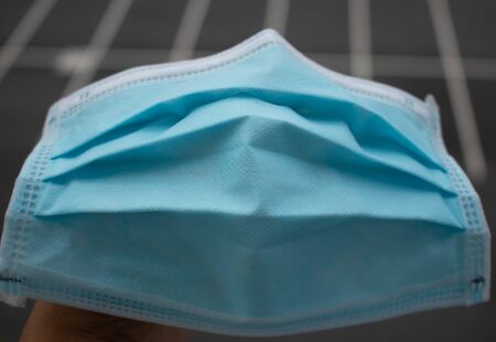 Close up Blue medical mask. to prevent the Virus Covid-19. is placed in the middle. gray background.