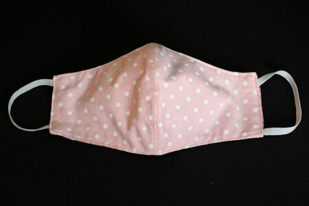 Handmade face masks made from cloth placed pink on black table, washable and reusable, can be used during shortage of surgical mask due to coronavirus pandemic. virus covid-19.の写真素材