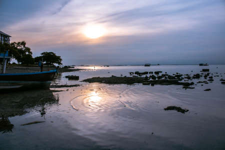 Warm light sunset beach sand boat mirror water ocean sea thailand asia sky orange cloud.