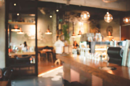 Blur coffee shop or cafe restaurant with abstract bokeh light image background.For montage product display or design key visual layout. Abstract defocused bokeh. orange, red, light. vintage effect.の写真素材