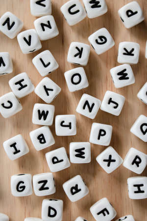 Text dice cube concept / Letter dices alphabet on wooden background. Block of alphabet studded on the floor.の写真素材