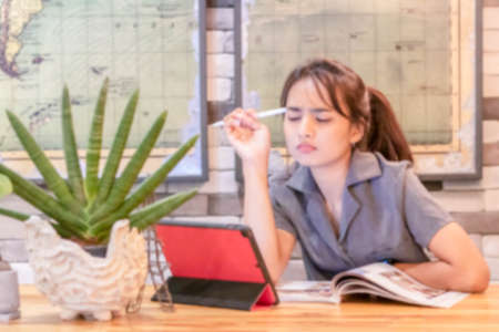 Blurred background : Attractive young woman working office with new freelance business startup. film effect ,reflections, bokeh, vintage filter.の写真素材