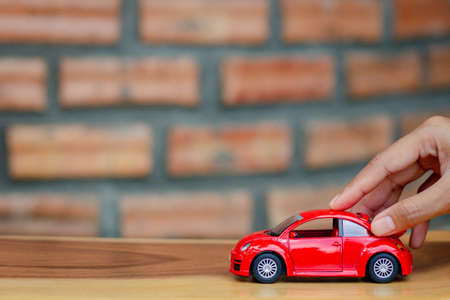 Chon buri, Thailand, September 07 , 2020. Car purchase concept. Toy car on woman's palm, Brick wall background. Vintage style. copy space.のeditorial素材