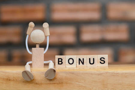 Dice the word "BONUS". Text dice cube concept / Letter dices alphabet on wooden background. Block of alphabet studded on the floor. bonus. coppy space.の写真素材