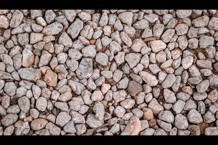 Ground stone grey background of many small stones. Rock texture background..