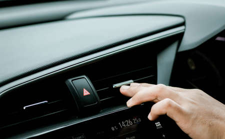 Driver checking flow of cold air from conditioning system in carの写真素材