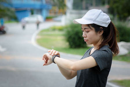 Woman setting up the fitness smart watch for running. Sportswoman checking watch device. copy space.の写真素材