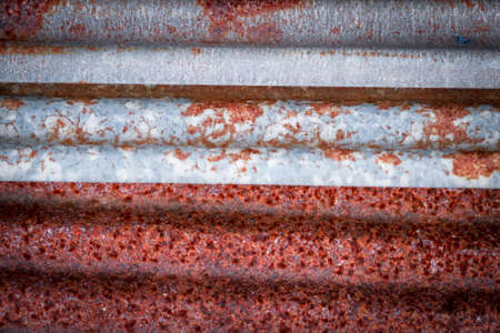 Sharp edges of the rusty metal sheets placed on the floor. Old aged weathered rusty galvanized corrugated iron sheet roof of abandoned mood. selective focus blur background. Vintage.with copy space and space for text.の写真素材