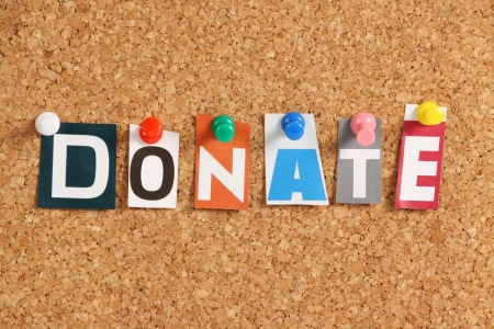 The word Donate in cut out magazine letters pinned to a cork notice boardの写真素材