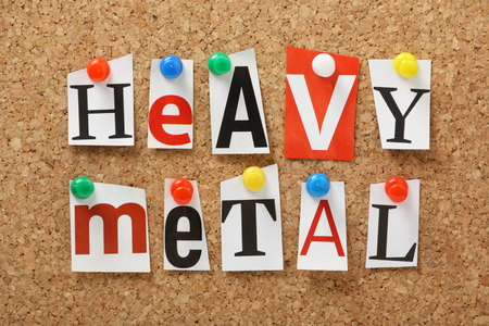 The words Heavy Metal in cut out magazine letters pinned to a cork notice boardの写真素材