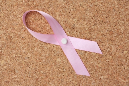 Pink Breast Cancer Awareness Ribbon pinned to a cork notice board as a reminder and symbolの写真素材