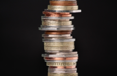 Stack of British coins on a dark background with copy space