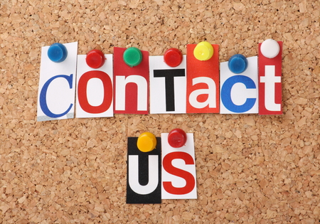 The words Contact Us in cut out magazine letters pinned to a cork notice boardの写真素材