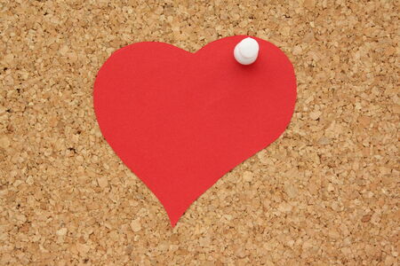 Red paper heart on a cork background as a reminder for St Valentine s Dayの写真素材