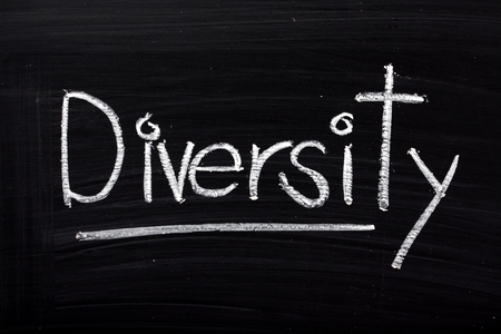 The word Diversity written in white chalk on a blackboardの写真素材