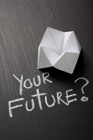 Origami Fortune Teller made from white paper on a blackboard next to the question Your Future  written by hand in chalkの写真素材