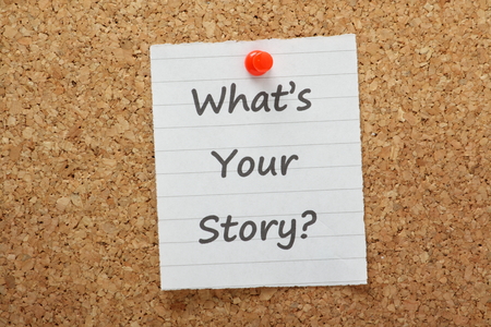 The phrase What s Your Story typed on a piece of lined paper pinned to a cork notice board