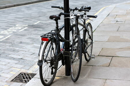 London, United Kingdom - October 08, 2009  Two bicycles left chained to a signpost in the City Of...