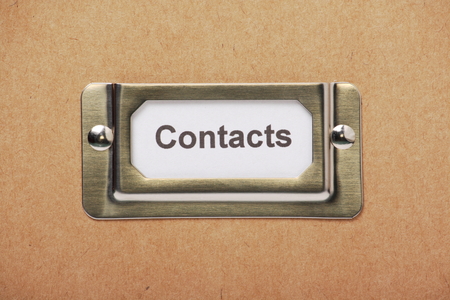 A label for Contacts in a metal holder on the outside of a cardboard storage boxの写真素材