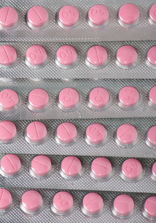 Generic pink pill blister packs stacked on top of each other
