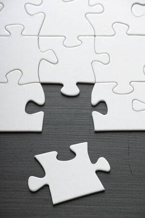 Final Jigsaw Piece Ready to Complete the Puzzle on a blackboardの写真素材
