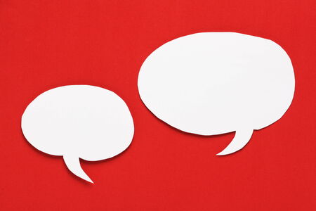 Blank white paper Speech Bubbles with copy space on a bright red paper backgroundの写真素材