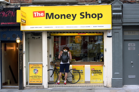 London, England - Sept 4th, 2014: A man stands at the window of The Money Shop in the Soho area of London. The Money Shop provides payday loans, pawn brokering and other financial services in the UKのeditorial素材