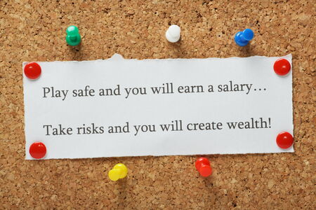Playing it safe versus taking risks concept for entrepreneurs or people in work typed on a piece of paper and pinned to a cork notice boardの写真素材