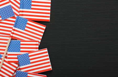 Miniature United States of America flags arranged on a blackboard with copy space