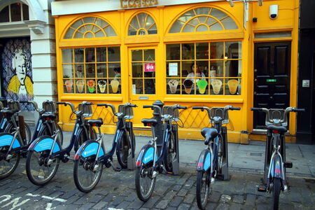 London, England - February 17, 2015: Barclays Bank bicycles parked in a row front of a colorful cafe in London, England. The rental scheme provides over 5000 bikes for hire across the city.のeditorial素材