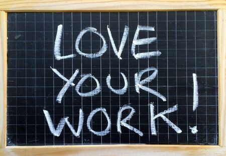 The words Love Your Work written by hand on a blackboard as a concept for employee and job satisfactionの写真素材
