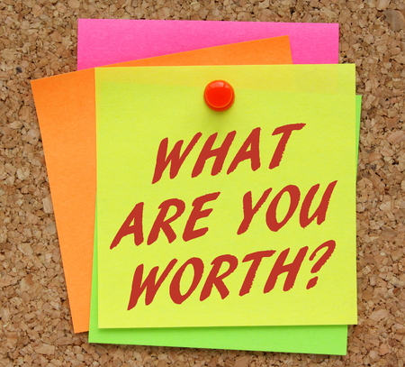 The question What Are You Worth in red text on a yellow sticky note as a reminder to assess your value in terms of financial rewardsの写真素材