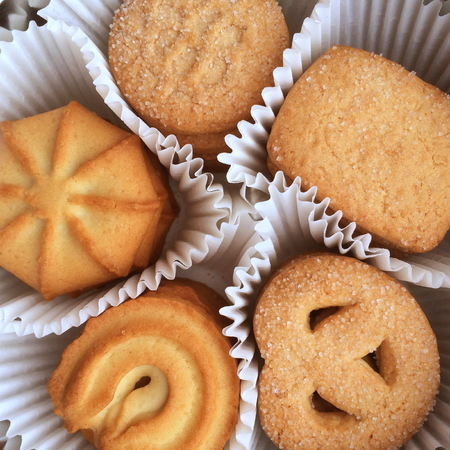 Selection of traditional Danish butter cookies from Denmark in their individual paper cases photographed from aboveの写真素材