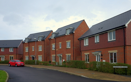 Bracknell, England - Nov 20, 2017: Row of new build red brick homes on a street with a car in the town of Bracknell, Englandのeditorial素材