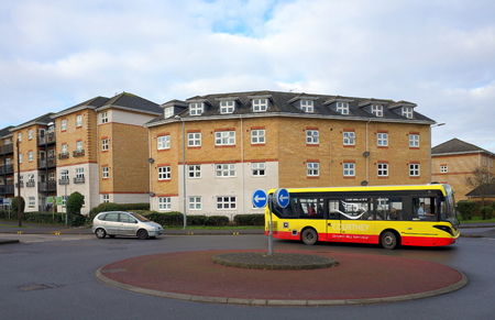 Bracknell,England - January 22, 2018: A local bus and a car negotiate a traffic roundabout in front of a modern residential apartment block in Bracknell, Englandのeditorial素材