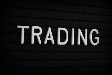 The word Trading in white plastic letters on a black letter boardの写真素材