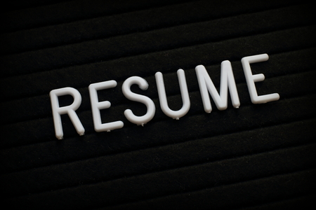 The word Resume in white plastic letters on a notice boardの写真素材