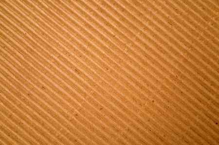 Brown corrugated cardboard paper background photographed on a diagonalの写真素材
