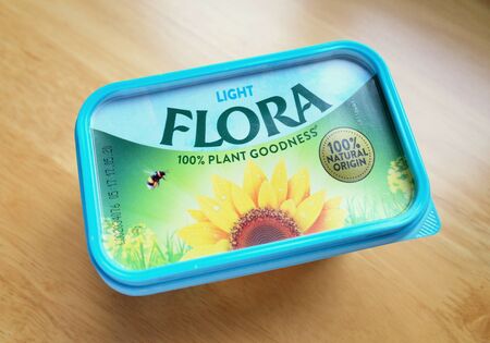 Bracknell, England - February 19, 2020: A tub of Flora Light margerine photographed from above. Flora provides spreads derived from Sunflower and other seed oils as an alternative to dairy productsのeditorial素材
