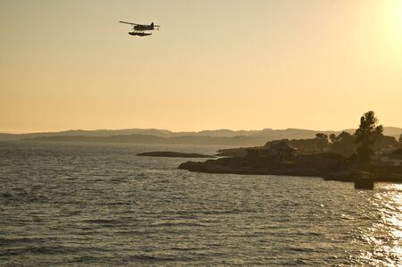 Sunset over Victoria from Ferry as Seaplane takes off.の写真素材