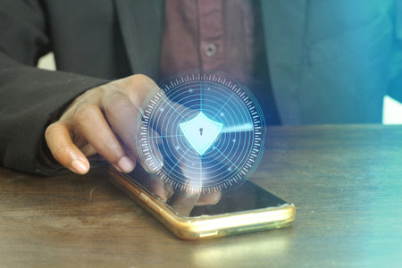 Businessperson with smartphone displaying futuristic security interface concept.