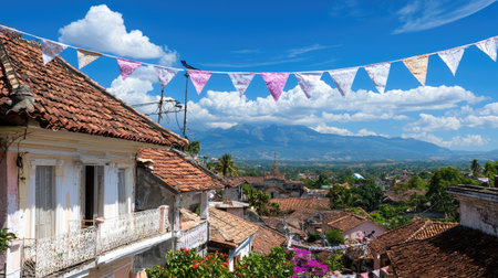 A picturesque view of a charming town with colorful bunting strung above. Majestic mountains rise in the background, creating a scenic and tranquil atmosphere.の素材