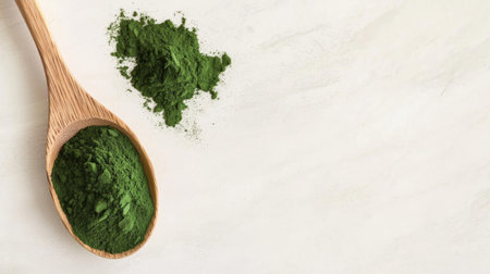 Green superfood powder displayed in a wooden spoon offers a vibrant visual for health and wellness. Perfect for nutrition-related projects.の素材