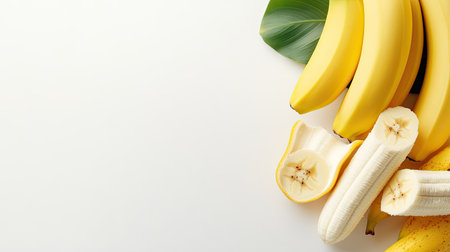 A vibrant arrangement of fresh bananas on a white background, featuring whole and sliced pieces alongside a green leaf, perfect for health and food themes.の素材