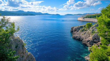 Experience the calm beauty of a coastal landscape featuring clear blue waters, rocky shores, and a vibrant sky, perfect for peaceful getaways and exploration.の素材