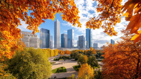 Stunning autumn cityscape featuring vibrant foliage framing modern skyscrapers under a blue sky. A perfect blend of nature and urban life.の素材